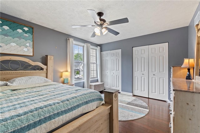 251 Commons Dr, Oakmont, PA 15139 - bedroom featuring multiple closets, dark wood-style floors, a textured ceiling, and a ceiling fan