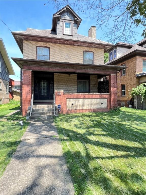 384 E End Ave, Beaver, PA 15009 - american foursquare style home with brick siding, a front yard, a chimney, and a porch