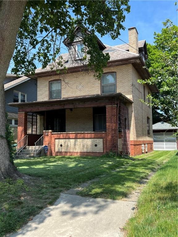 384 E End Ave, Beaver, PA 15009 - view of front facade featuring brick siding, a chimney, a front lawn, covered porch, and a detached garage