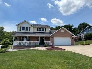 2355 School St, Mount Pleasant Twp Wml, PA 15666 - view of front of house with an attached garage, a front yard, concrete driveway, and a porch