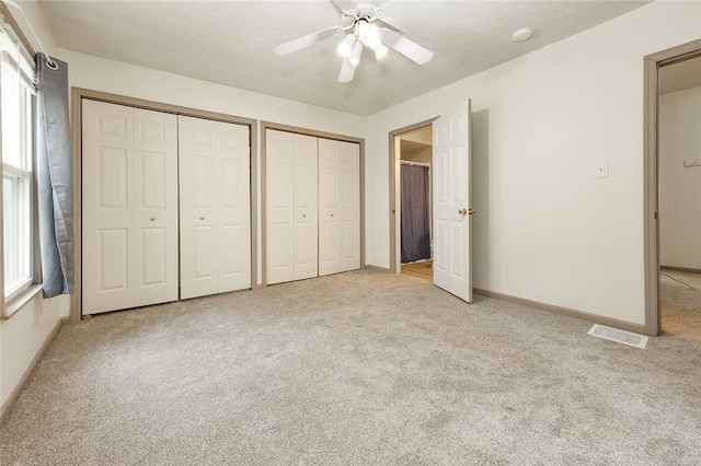 407 Hill St, Grove City Boro, PA 16127 - unfurnished bedroom featuring light carpet, two closets, multiple windows, and ceiling fan