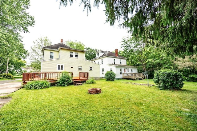 407 Hill St, Grove City Boro, PA 16127 - back of property with an outdoor fire pit, a chimney, a wooden deck, and a lawn