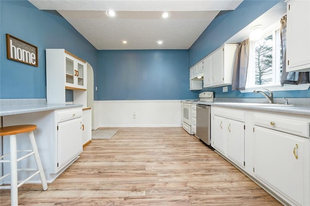 407 Hill St, Grove City Boro, PA 16127 - kitchen with stainless steel dishwasher, white cabinetry, white stove, light wood finished floors, and light countertops