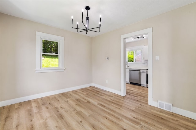 404 Ariston Ave, Carrick, PA 15210 - empty room with a chandelier and light wood-style flooring