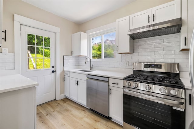 404 Ariston Ave, Carrick, PA 15210 - kitchen featuring appliances with stainless steel finishes, exhaust hood, light countertops, and light wood finished floors