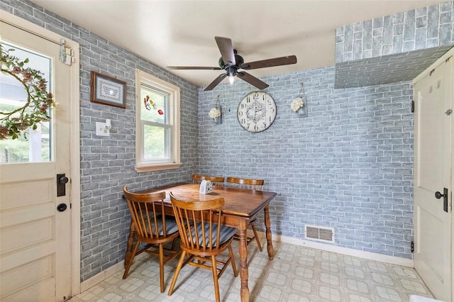 623 Rte 30, Findlay Twp, PA 15126 - dining area featuring healthy amount of natural light, ceiling fan, light floors, and brick wall