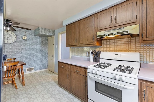623 Rte 30, Findlay Twp, PA 15126 - kitchen with white range with gas cooktop, under cabinet range hood, a ceiling fan, and light countertops