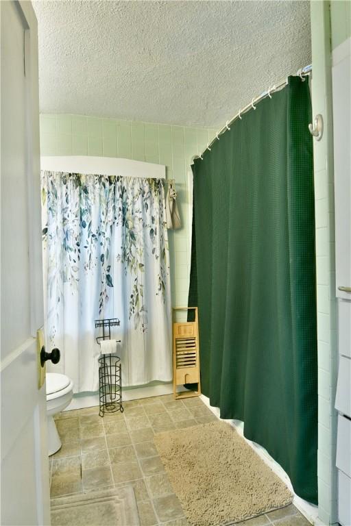 1107 W Ridge Ave, Sharpsville, PA 16150 - full bathroom with a textured ceiling, a shower with curtain, and stone finish flooring