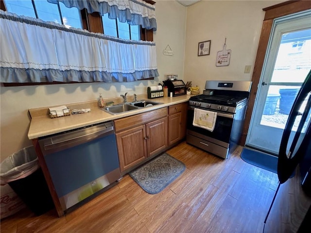 1506 Victoria Ave, New Kensington, PA 15068 - kitchen featuring appliances with stainless steel finishes, light wood-type flooring, light countertops, and brown cabinetry