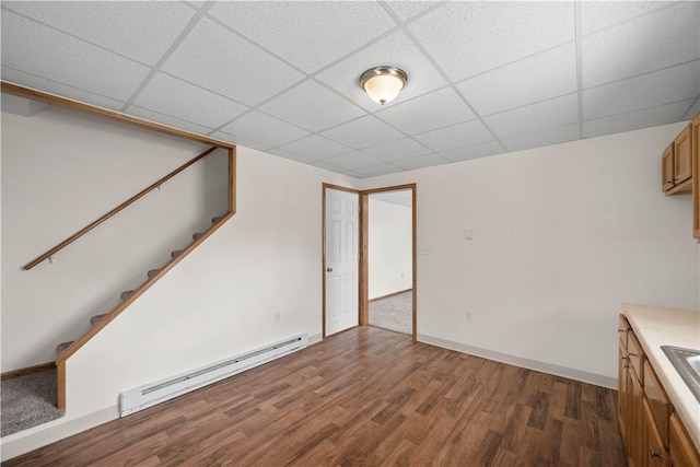 26-28 Clopper St, Sewickley Twp, PA 15637 - basement with a baseboard radiator, wood finished floors, a drop ceiling, and stairway
