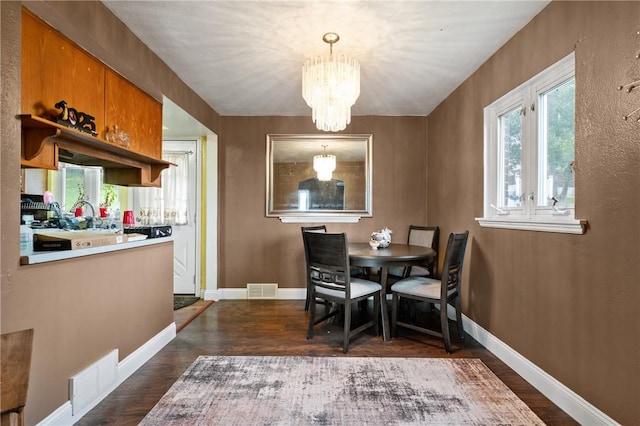 615 School St, West Mifflin, PA 15122 - dining space with dark wood-style flooring and a chandelier