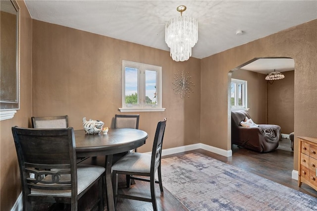 615 School St, West Mifflin, PA 15122 - dining area featuring a chandelier, arched walkways, and wood finished floors
