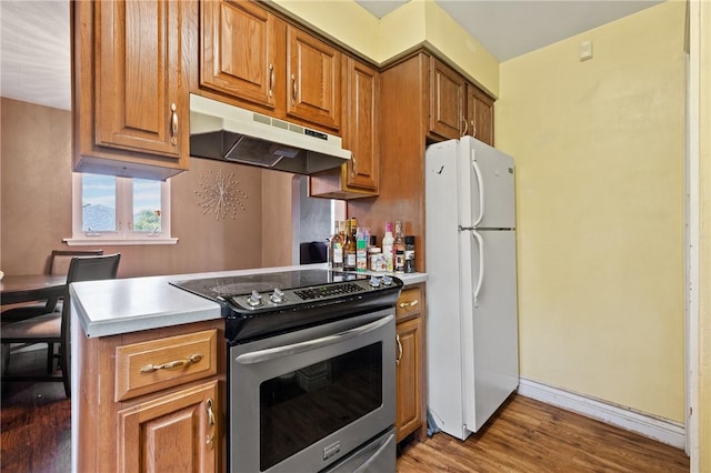 615 School St, West Mifflin, PA 15122 - kitchen featuring electric range, freestanding refrigerator, under cabinet range hood, wood finished floors, and brown cabinets