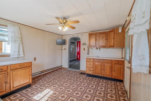 101 7th St, Monongahela City, PA 15063 - kitchen with arched walkways, light countertops, ceiling fan, brown cabinetry, and wooden walls