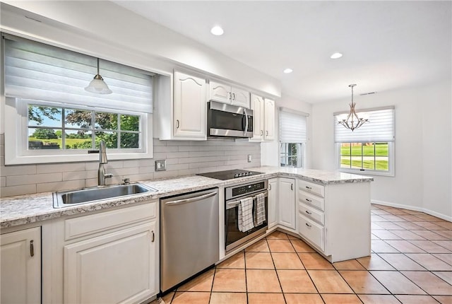 117 Clubhouse Cir, Shenango Twp Mer, PA 16159 - kitchen with appliances with stainless steel finishes, backsplash, white cabinets, a peninsula, and a chandelier