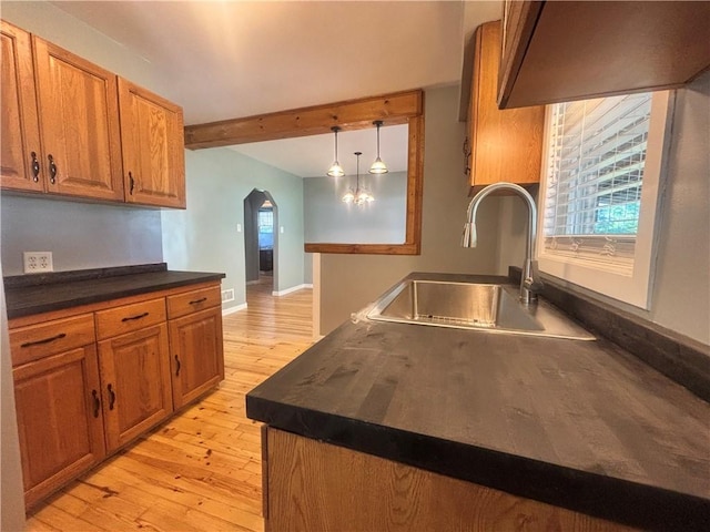 26 Mount View Dr, Burgettstown Boro, PA 15021 - kitchen with arched walkways, dark countertops, brown cabinets, light wood-style flooring, and beamed ceiling