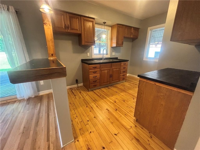 26 Mount View Dr, Burgettstown Boro, PA 15021 - kitchen featuring light wood-type flooring, brown cabinets, dark countertops, and plenty of natural light