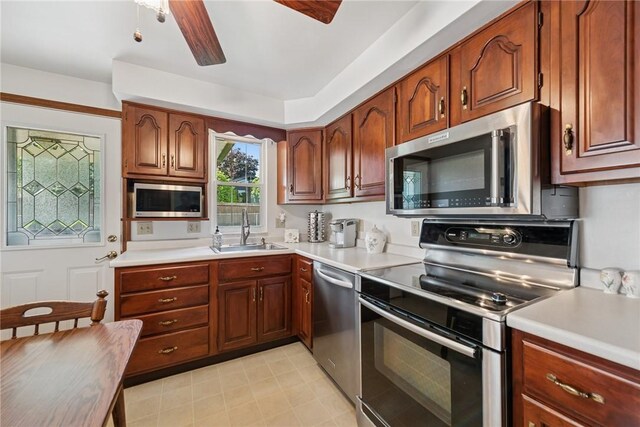 1952 Dearborn Dr, White Oak, PA 15131 - kitchen featuring appliances with stainless steel finishes, light countertops, a ceiling fan, and brown cabinetry