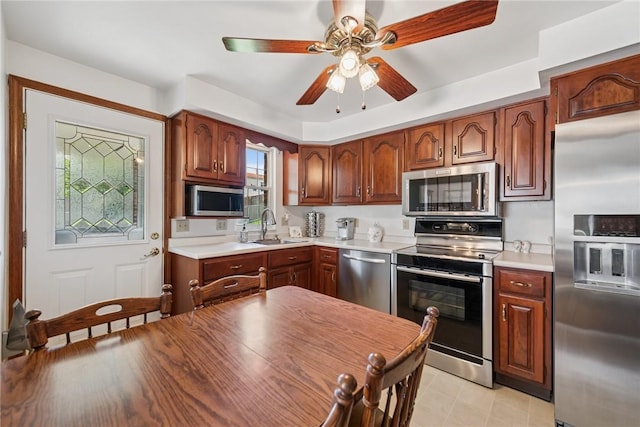1952 Dearborn Dr, White Oak, PA 15131 - kitchen featuring appliances with stainless steel finishes, light countertops, ceiling fan, and brown cabinets