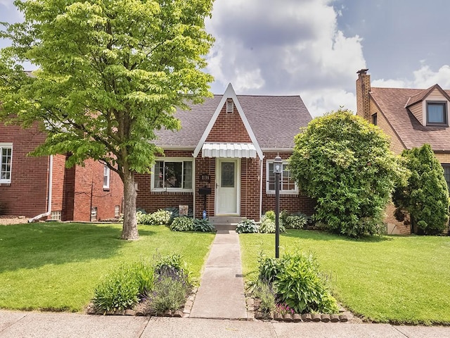 1138 Union Ave, Brackenridge, PA 15014 - tudor-style house with brick siding, a front yard, and roof with shingles