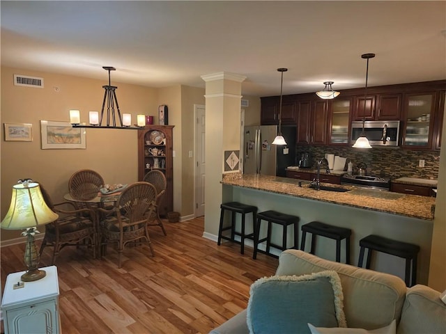 7007 Stefano Dr, Delmont, PA 15626 - kitchen featuring stainless steel appliances, a kitchen bar, decorative backsplash, glass insert cabinets, and stone countertops