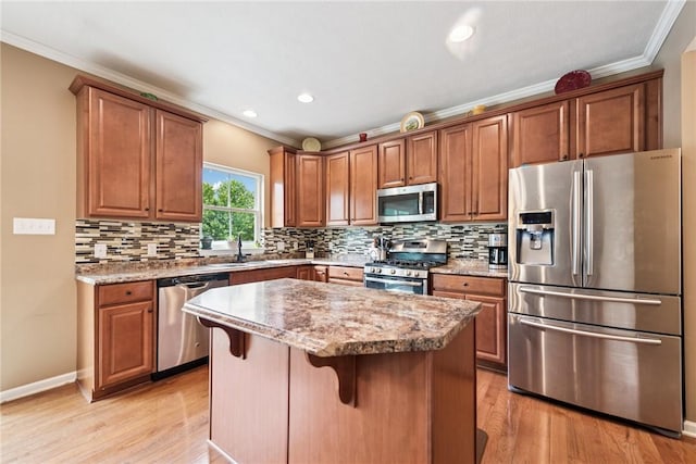 509 Saddle Ridge Dr, Penn Twp Wml, PA 15642 - kitchen with stainless steel appliances, crown molding, a kitchen island, light wood finished floors, and tasteful backsplash