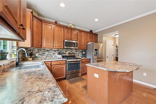 509 Saddle Ridge Dr, Penn Twp Wml, PA 15642 - kitchen featuring stainless steel appliances, a center island, ornamental molding, light wood finished floors, and tasteful backsplash