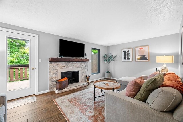 206 Little Hollow Dr, Aleppo, PA 15143 - living room featuring wood finished floors, a stone fireplace, and a textured ceiling