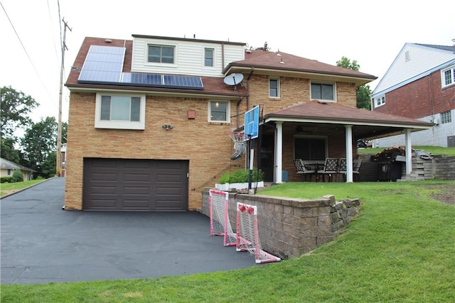 533 Charlotte Dr, Baldwin Boro, PA 15236 - view of front facade featuring an attached garage, brick siding, a front yard, driveway, and solar panels