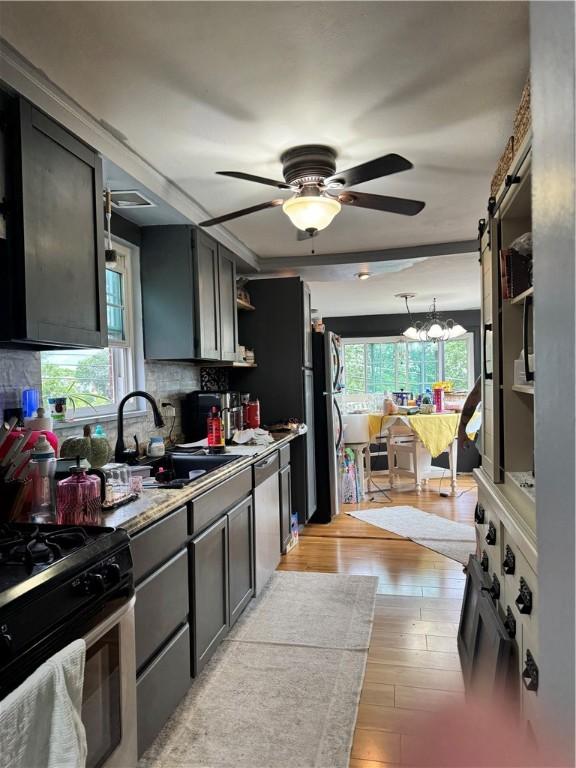 217 Livingston Rd, West Mifflin, PA 15122 - kitchen featuring open shelves, ceiling fan, light wood finished floors, stainless steel gas range, and tasteful backsplash
