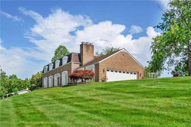 585 Taylor Dr, North Strabane, PA 15317 - back of property featuring brick siding, a lawn, an attached garage, a chimney, and mansard roof