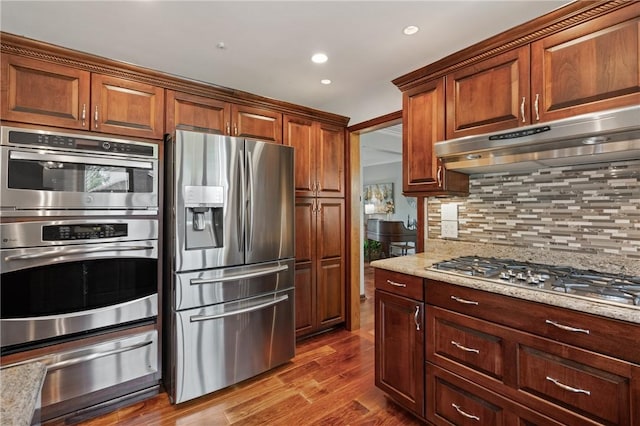 585 Taylor Dr, North Strabane, PA 15317 - kitchen featuring stainless steel appliances, a warming drawer, decorative backsplash, dark wood finished floors, and under cabinet range hood