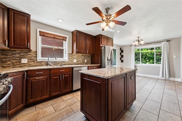 4057 Eliza St, West Mifflin, PA 15122 - kitchen with appliances with stainless steel finishes, decorative backsplash, a ceiling fan, light tile patterned flooring, and light stone counters