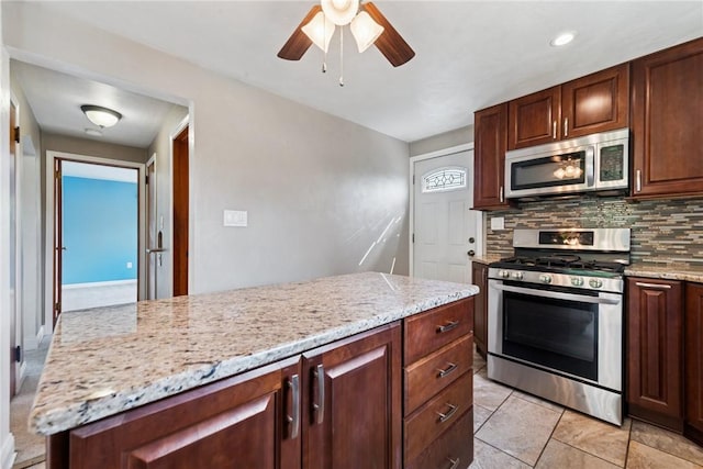 4057 Eliza St, West Mifflin, PA 15122 - kitchen with appliances with stainless steel finishes, tasteful backsplash, ceiling fan, and light stone countertops