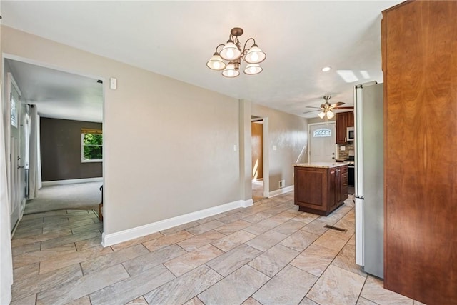 4057 Eliza St, West Mifflin, PA 15122 - kitchen featuring light countertops, freestanding refrigerator, ceiling fan, stainless steel microwave, and a chandelier