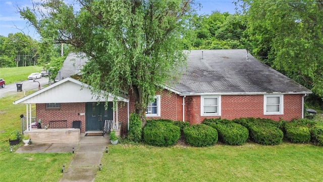 117 Carroll St, Aliquippa, PA 15001 - view of front facade featuring brick siding, a front yard, a porch, and roof with shingles