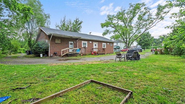 117 Carroll St, Aliquippa, PA 15001 - back of house featuring a lawn, brick siding, and a garden