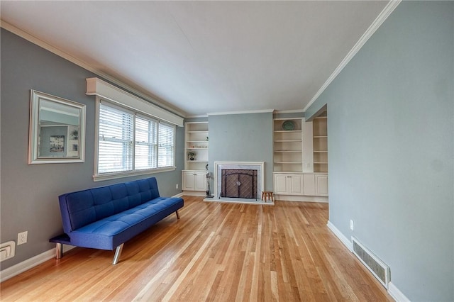 6833 Meade St Unit 17, Point Breeze, PA 15208 - living room featuring built in features, light wood-type flooring, a fireplace with raised hearth, and crown molding