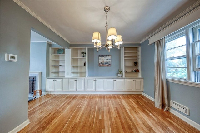 6833 Meade St Unit 17, Point Breeze, PA 15208 - unfurnished dining area with a chandelier, light wood-type flooring, crown molding, and built in shelves