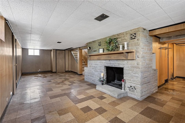 17 Fremont Rd, Pa, PA 15022 - unfurnished living room featuring tile patterned floors, stairs, a fireplace, and wooden walls