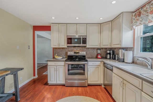 1230 Northwestern Dr, Monroeville, PA 15146 - kitchen with appliances with stainless steel finishes, backsplash, light wood-type flooring, light countertops, and recessed lighting