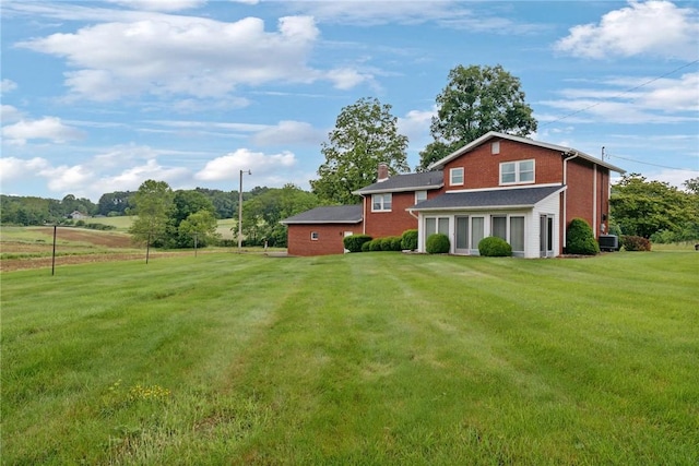 207 State Park Rd, New Alexandria, PA 15670 - back of house with a chimney, a lawn, and brick siding