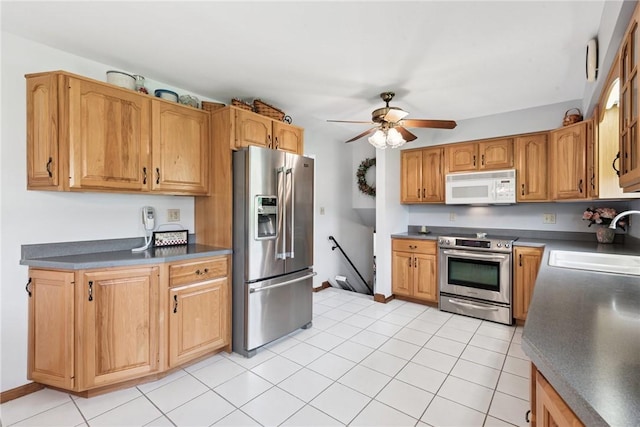 207 State Park Rd, New Alexandria, PA 15670 - kitchen featuring stainless steel appliances, ceiling fan, dark countertops, and light tile patterned floors
