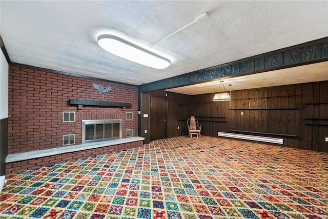 207 State Park Rd, New Alexandria, PA 15670 - finished below grade area featuring baseboard heating, wooden walls, a textured ceiling, and a fireplace