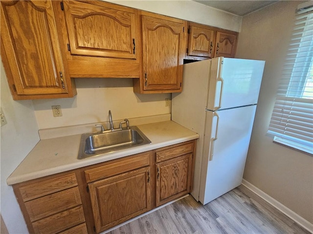 4235 Willow Ave, Castle Shannon, PA 15234 - kitchen with freestanding refrigerator, light wood finished floors, brown cabinetry, and light countertops