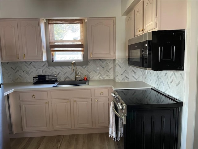 1022 Dewey Ave, New Castle/3Rd, PA 16101 - kitchen with range with electric cooktop, black microwave, light countertops, decorative backsplash, and light wood-style flooring