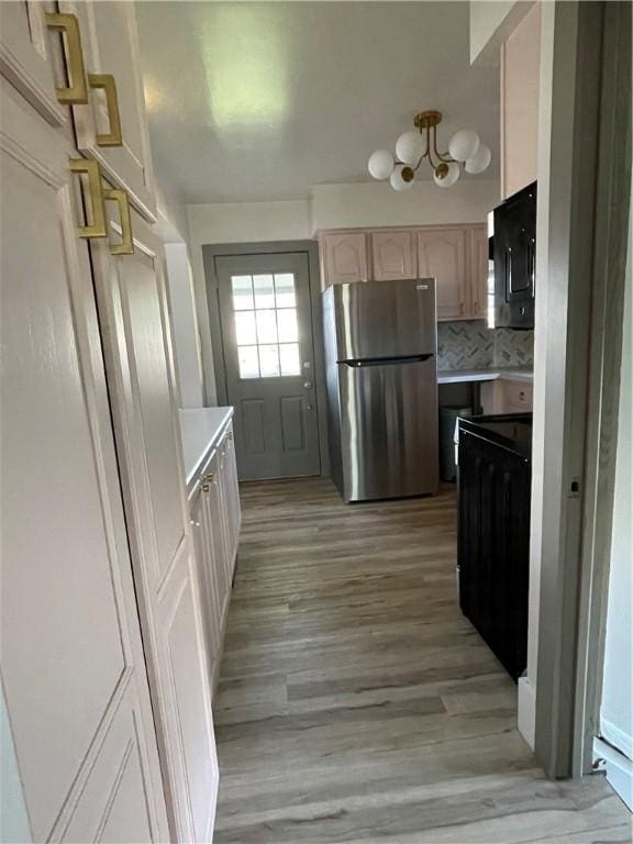 1022 Dewey Ave, New Castle/3Rd, PA 16101 - kitchen featuring freestanding refrigerator, black microwave, light countertops, light wood-style floors, and a chandelier