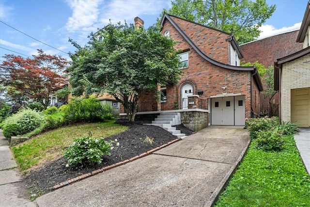 7032 Reynolds St, Point Breeze, PA 15208 - tudor house featuring driveway, brick siding, and a garage