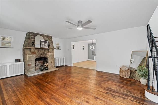 7032 Reynolds St, Point Breeze, PA 15208 - unfurnished living room featuring radiator, a ceiling fan, wood finished floors, and a fireplace