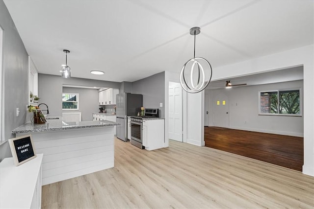 7032 Reynolds St, Point Breeze, PA 15208 - kitchen with appliances with stainless steel finishes, light wood-style flooring, white cabinets, ceiling fan, and light stone countertops